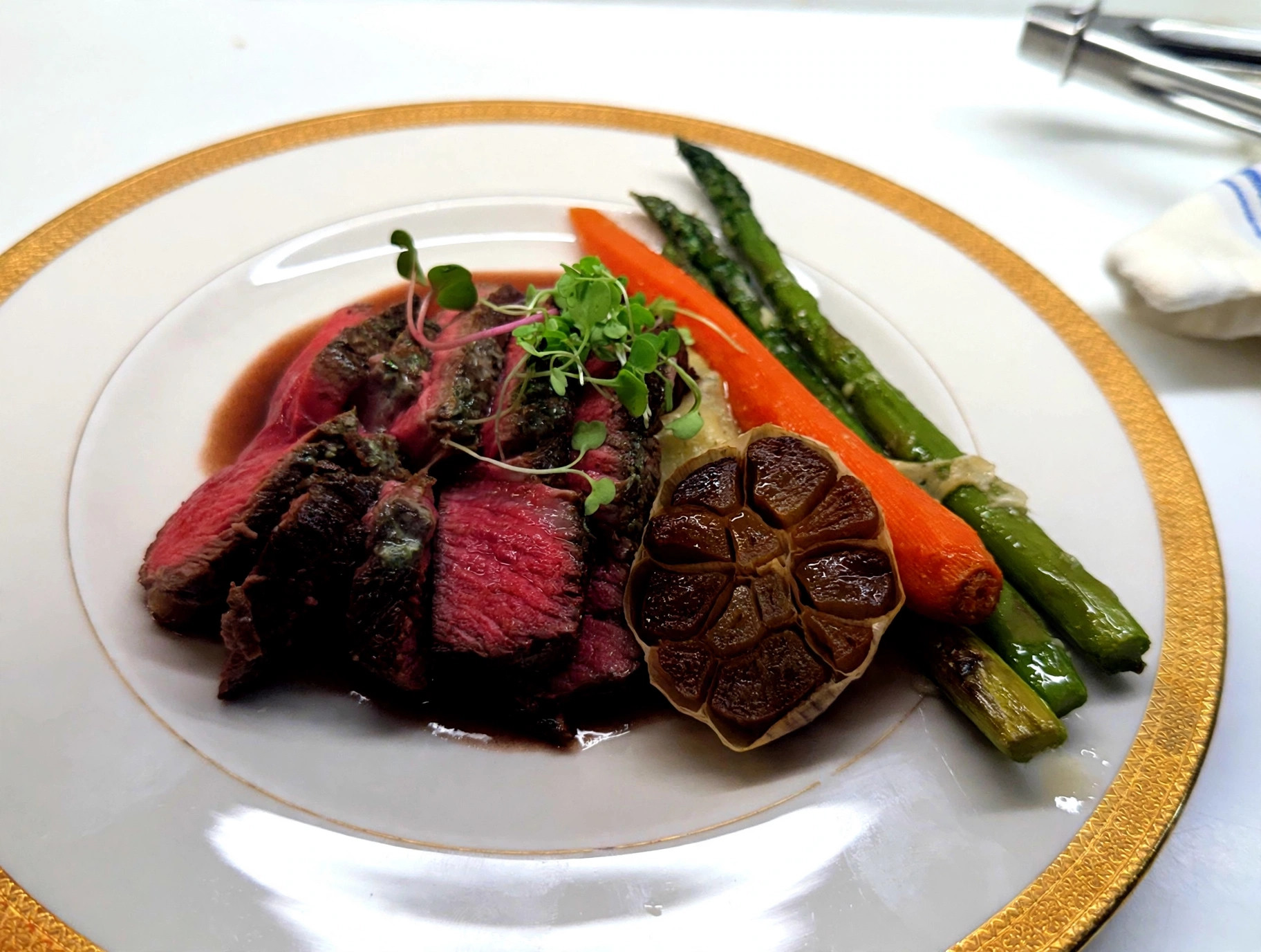 Sliced beef tenderloin with asparagus, roasted carrot and roasted garlic