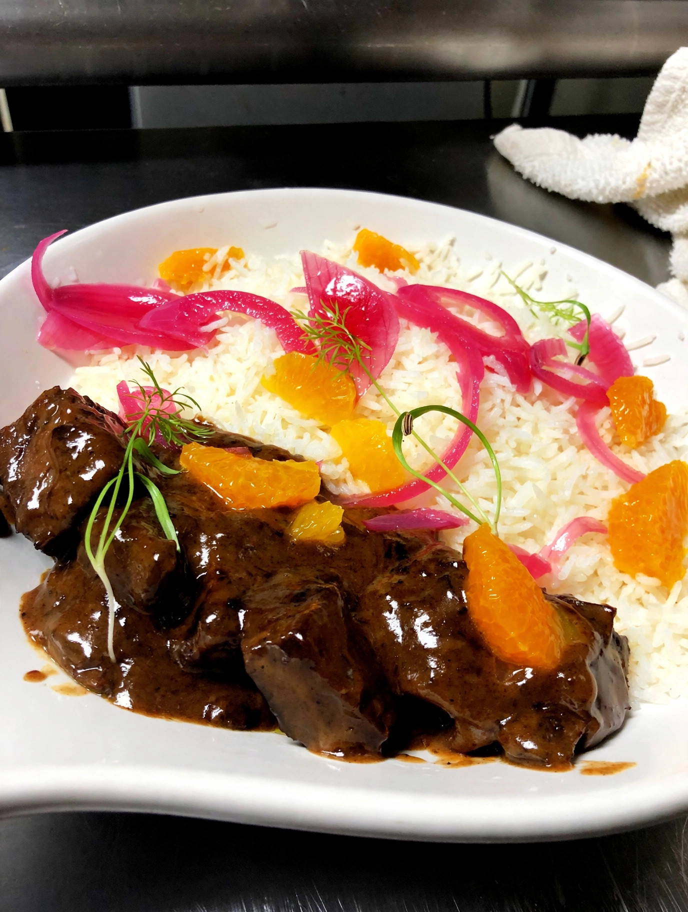 Braised beef with rice, pickled onions and orange
