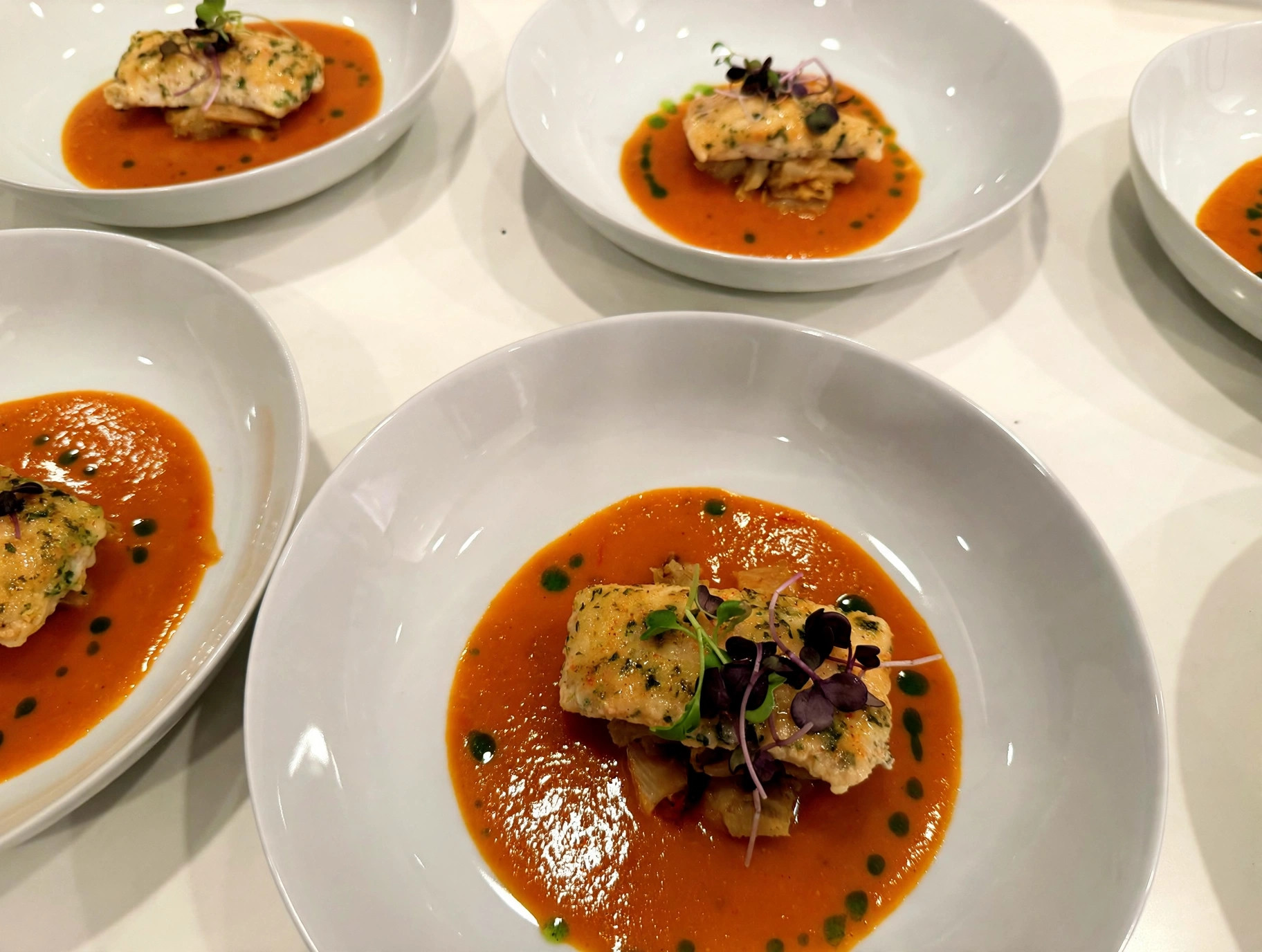 Herb-crusted fish over butternut squash sauce with microgreens