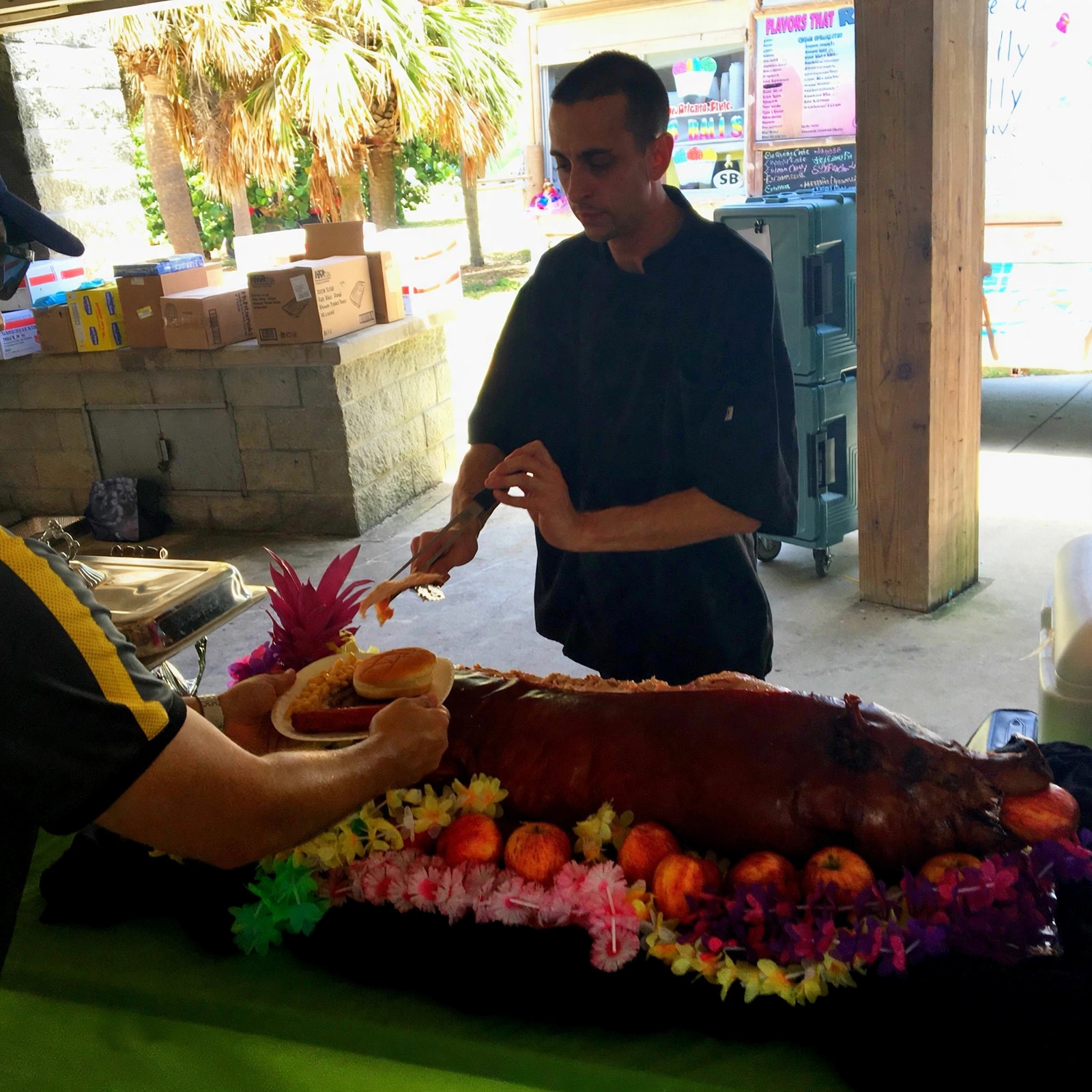 Chef Tony carving a whole roasted pig at an outdoor event