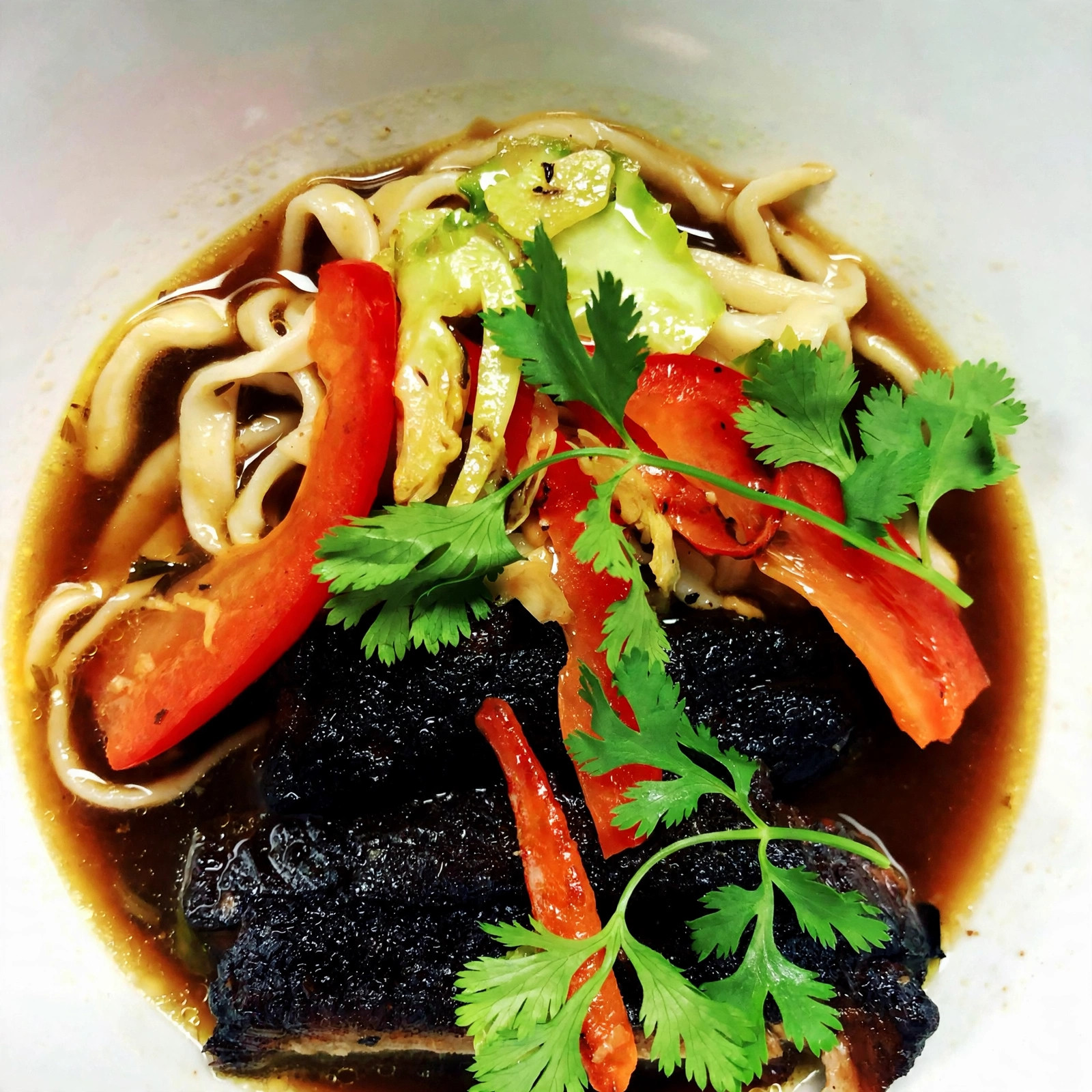 Braised short rib noodle bowl with peppers and cilantro